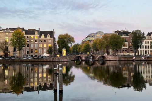 a river in a city with buildings and a bridge at SWEETS - Walter Süskindbrug in Amsterdam