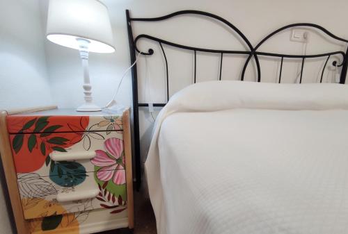 een slaapkamer met een bed met een lamp ernaast bij Apartamento Alameda Garden in Yecla