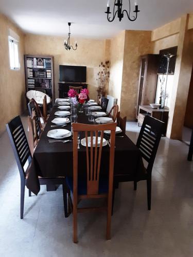 a dining room with a black table and chairs at JARAMUNDI in Villa del Prado