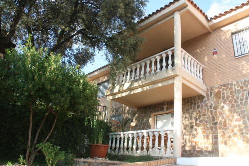 a house with a balcony on the side of it at JARAMUNDI in Villa del Prado