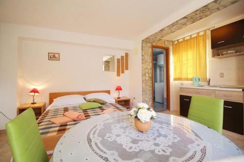 a room with a table and a bed and a kitchen at Apartmani L&Z in Petrcane
