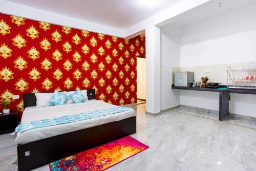 a bedroom with a bed and a red wall at Goan Fiesta Studio CALANGUTE GOA in Calangute