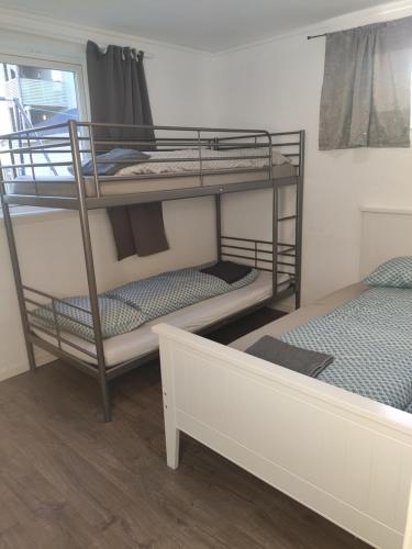 um quarto com 2 beliches e uma cama em FeelHome 2 bedrooms apartment Vidarsveg em Tromsø