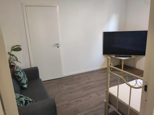 a living room with a tv and a couch at FeelHome 2 bedrooms apartment Vidarsveg in Tromsø