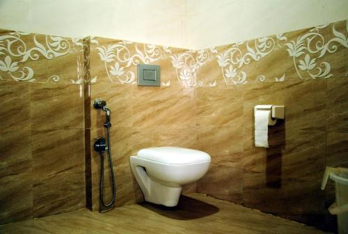 a bathroom with a toilet and a shower at Hotel La Gowri, Coorg in Madikeri