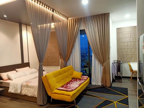 um quarto com uma cama amarela e uma cadeira amarela em Sri Kejora Vista Bangi Homestay -Studio em Kajang