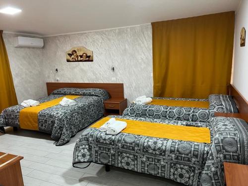 a hotel room with three beds in a room at La Casa Di Chiaretta in Falerna
