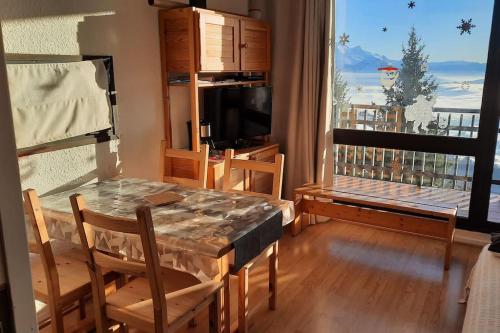 une salle à manger avec une table et des chaises et une fenêtre dans l'établissement Appartement de montagne en Matheysine, à Saint-Honoré