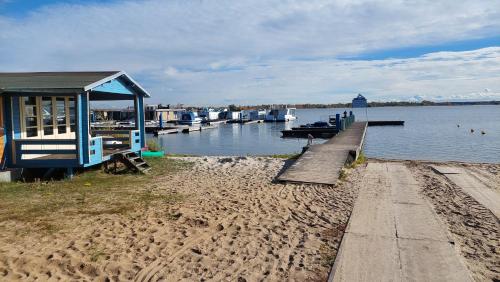 a dock with a house and boats in the water at Comtesse-Camping Plauer See in Brandenburg an der Havel