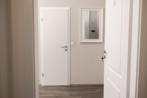 a white door with a mirror in a room at 4flats in Maribor