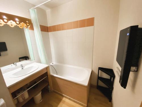 uma casa de banho com um lavatório e uma banheira em Appartement Samoëns, 2 pièces, 5 personnes - FR-1-624-102 em Samoëns