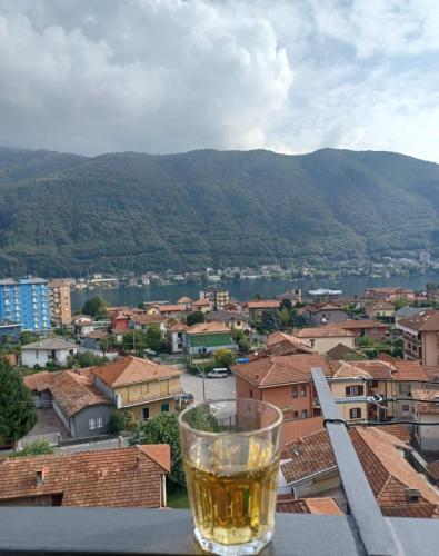 a glass of beer sitting on a ledge overlooking a city at Sweet lake Vi aspetta sul lago in Omegna