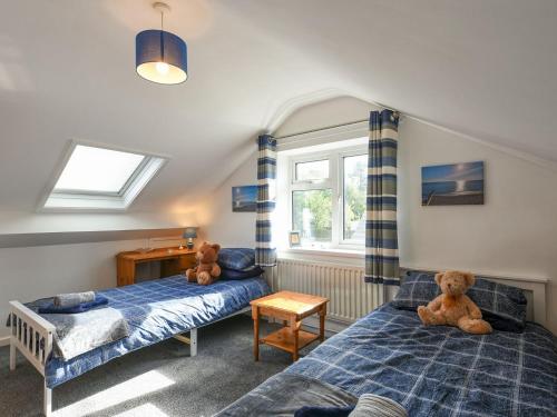 a bedroom with two beds and two teddy bears at Maldwyn in Llanegryn