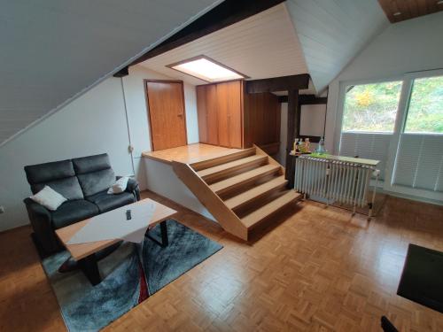 a living room with a staircase and a couch at Ferienapartment: An Der Kunstakademie Heimbach in Heimbach