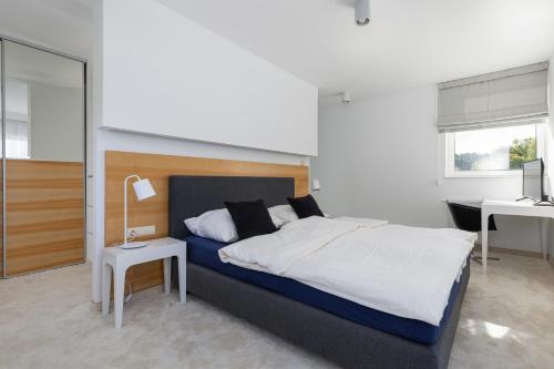 a bedroom with a large bed and a desk at Luxury Apartment Pogorzelica in Pogorzelica
