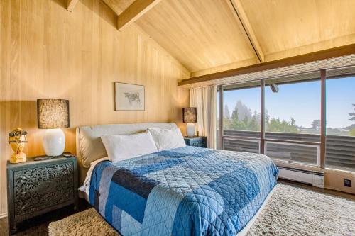 een slaapkamer met een bed en een groot raam bij Shoreline Sanctuary in Shoreline