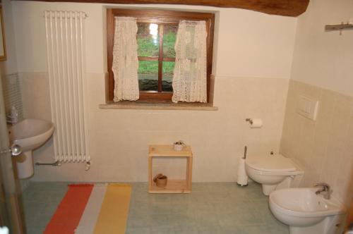 a bathroom with a toilet and a sink and a window at Sere di Sosta in Bagnolo Piemonte