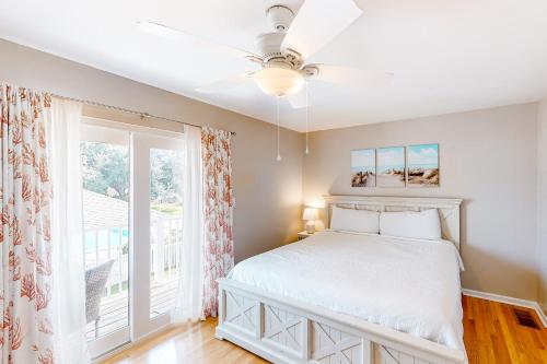 a bedroom with a bed with a ceiling fan and a window at Woodland Shores #20 in Destin