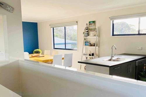 a kitchen with a sink and a table in it at Racing Penguin Surf Grand Prix Walk Phillip Island in Sunset Strip