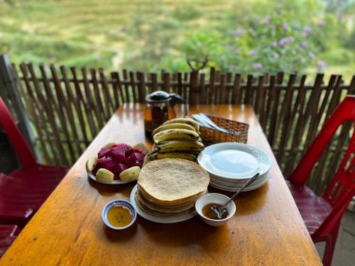 a wooden table with plates and bowls of food on it at SaPa Big Tree Hmong Homestay in Sa Pa