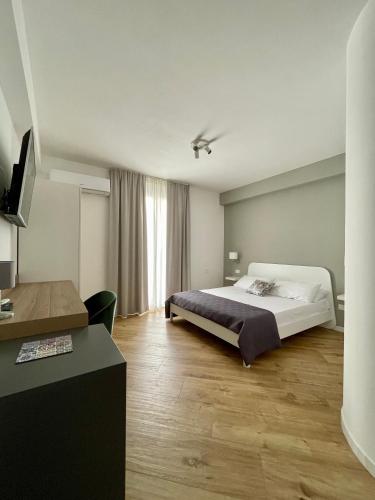 a bedroom with a large bed and a desk at ALBARIA ROOMS-APARTMENTS in Marsala