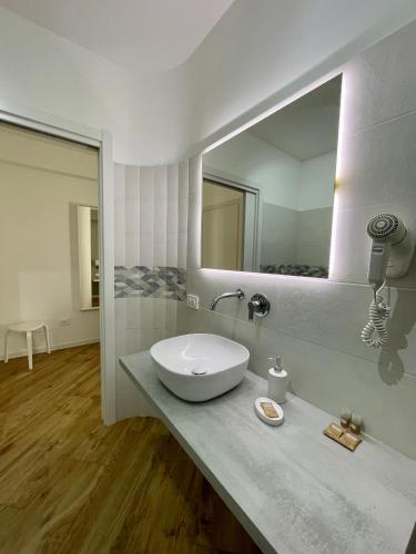 Un baño con lavabo y un espejo grande. en ALBARIA ROOMS-APARTMENTS, en Marsala
