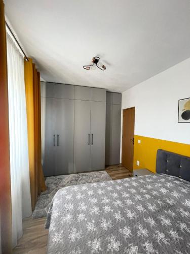 a bedroom with a bed and a ceiling fan at Cozy Apartment - near Airport and Palas Mall in Iaşi