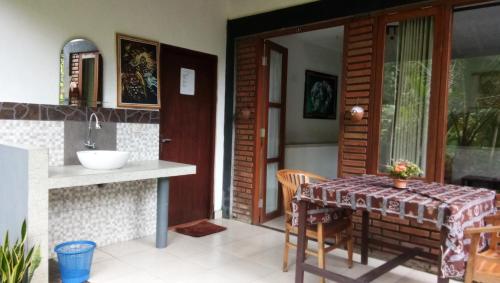 a kitchen and dining room with a table and a sink at Khrisna Hs and Cottages in Sidemen