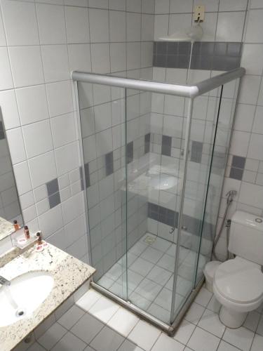 uma casa de banho com um chuveiro, um WC e um lavatório. em Flat Athenas 611 em Salvador
