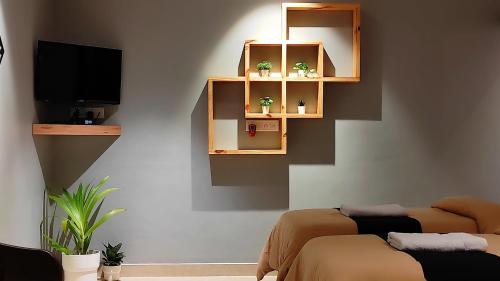 a living room with a tv and shelves with plants at Siolim Suites in Siolim