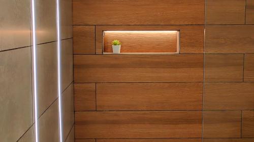 a wooden wall with a window and a potted plant at Siolim Suites in Siolim
