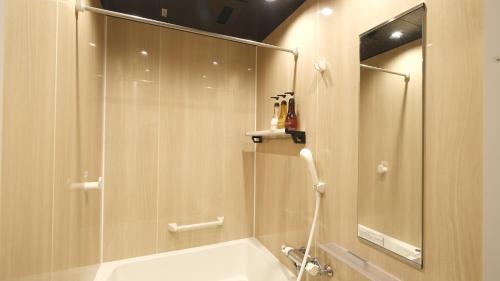 La salle de bains est pourvue d'une douche, d'une baignoire et d'un miroir. dans l'établissement 東瀛Stays402奈良　お洒落な和洋室, à Osaka