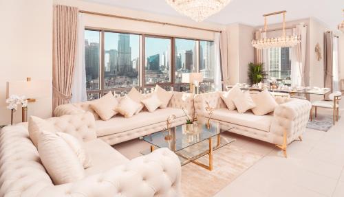 a living room with white furniture and a large window at Elite Royal Apartment - Panoramic Full Burj Khalifa, Fountain & Skyline view - Baron in Dubai