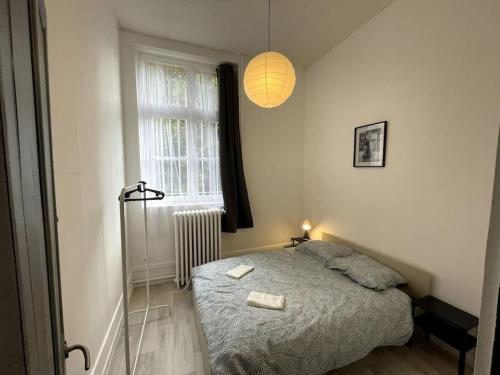 a small bedroom with a bed and a window at Agréable maison de ville dans la plus belle Avenue in Orléans