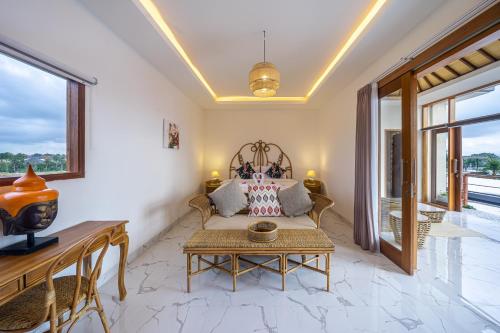 a living room with a couch and a table at Kasmaran Bali Guest House in Munggu
