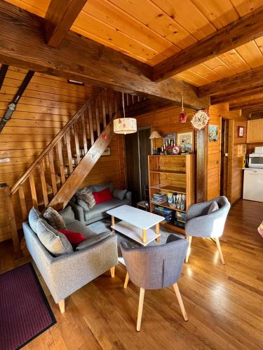 - un salon avec un canapé et des chaises dans une cabine dans l'établissement Chalet calme cosy Eyne station 2600, à Eyne