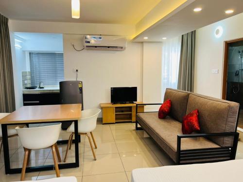 - un salon avec un canapé et une table dans l'établissement The White Orchid Luxury Service Apartments, à Ernakulam