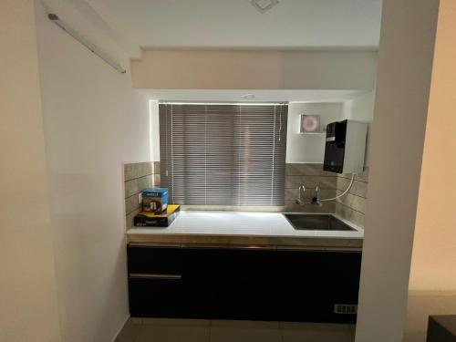 a kitchen with a sink and a window at The White Orchid Luxury Service Apartments in Ernakulam