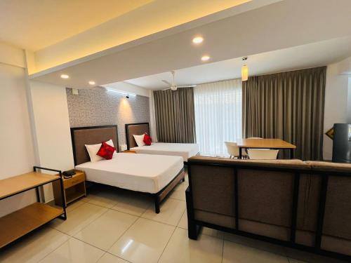 una camera d'albergo con due letti e un tavolo di The White Orchid Luxury Service Apartments a Ernakulam