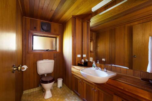 a wooden bathroom with a sink and a toilet at Stableford Lodge in Blackheath