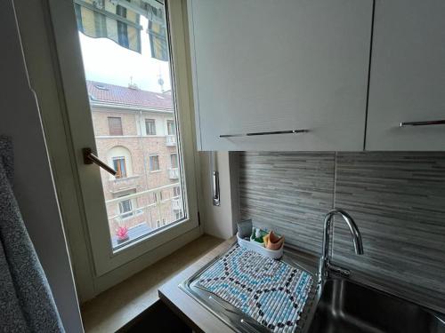 een keuken met een wastafel en een raam naast een aanrecht bij ATTICO BRICCARELLO -Intero Appartamento- Elegant Suite with FREE WIFI near PalaAlpitour and Sporting Club Torino-Olimpyc Stadium in Turijn