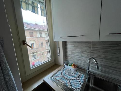 a kitchen with a sink and a window next to a counter at ATTICO BRICCARELLO -Intero Appartamento- Elegant Suite with FREE WIFI near PalaAlpitour and Sporting Club Torino-Olimpyc Stadium in Turin