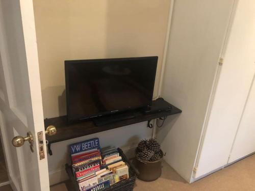 a television on a shelf in a room with books at Lovely rental unit with No loadshedding in Sandton