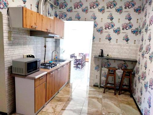 cocina con microondas y encimera en Private House 9, en Beregovo