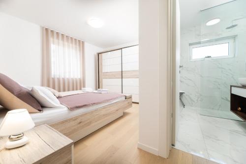 Un dormitorio con una cama y una ducha de cristal. en Sun Residence Krk, en Krk