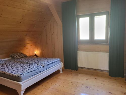 a bedroom with a bed and a window at Willa Wirchnia in Małastów