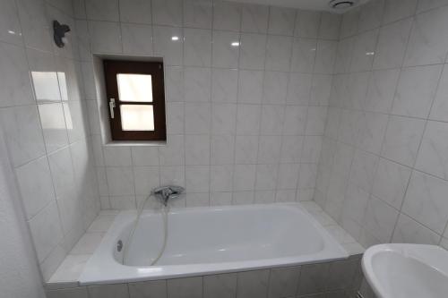 a white bath tub in a bathroom with a window at HOMEDAY F2 tous confort très bien placé num4 in Haguenau