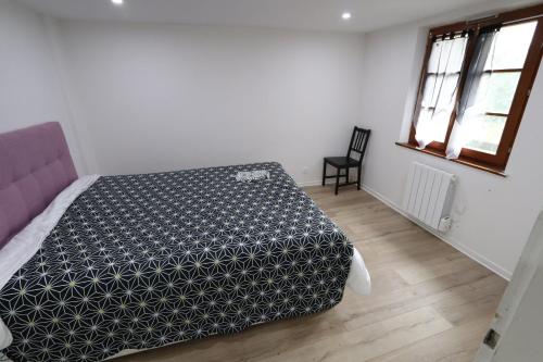 1 dormitorio con 1 cama en blanco y negro y 1 silla en HOMEDAY F2 tous confort très bien placé num4, en Haguenau