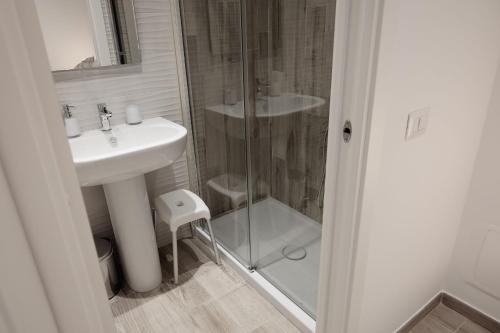 uma casa de banho com um lavatório e uma cabina de duche em vidro. em Central Guest House em Civitavecchia