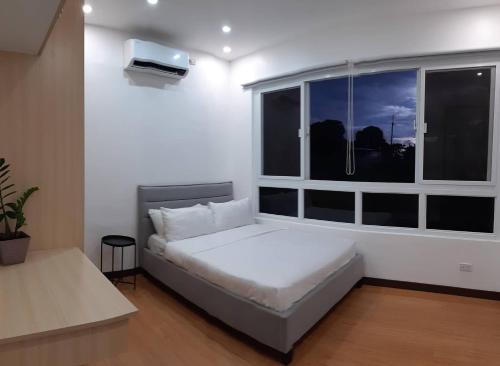 a small bedroom with a bed and a window at Das Haus Tagaytay in Tagaytay